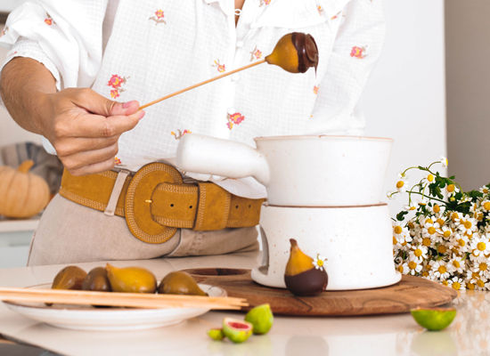 Imágen de Lupe Herrera elaborando un postre de higos con la fondue de la marca Ofelia.